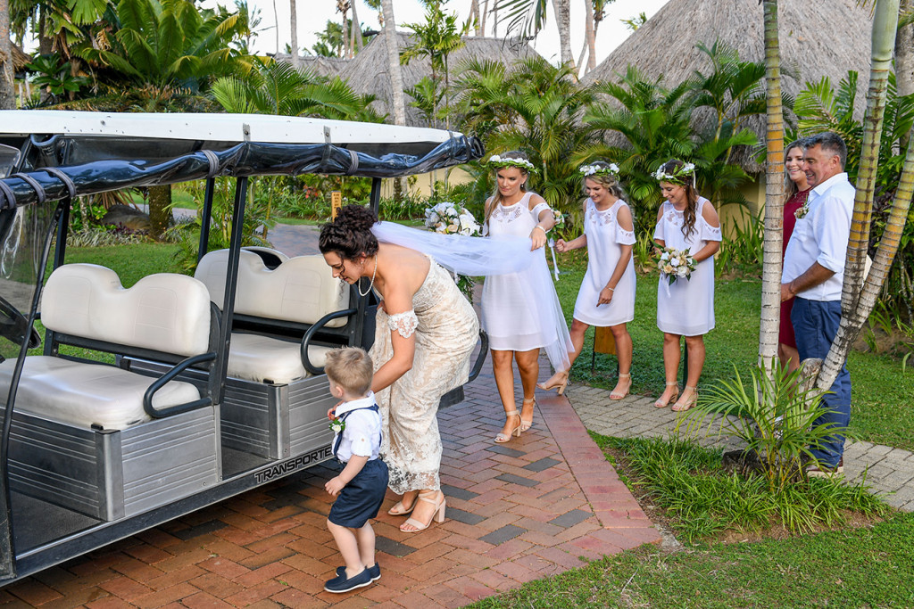 Bride getting into golf cart with bridesmaids