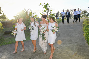 Bohemian bride and bridesmaids walk down hill in Outrigger Fiji
