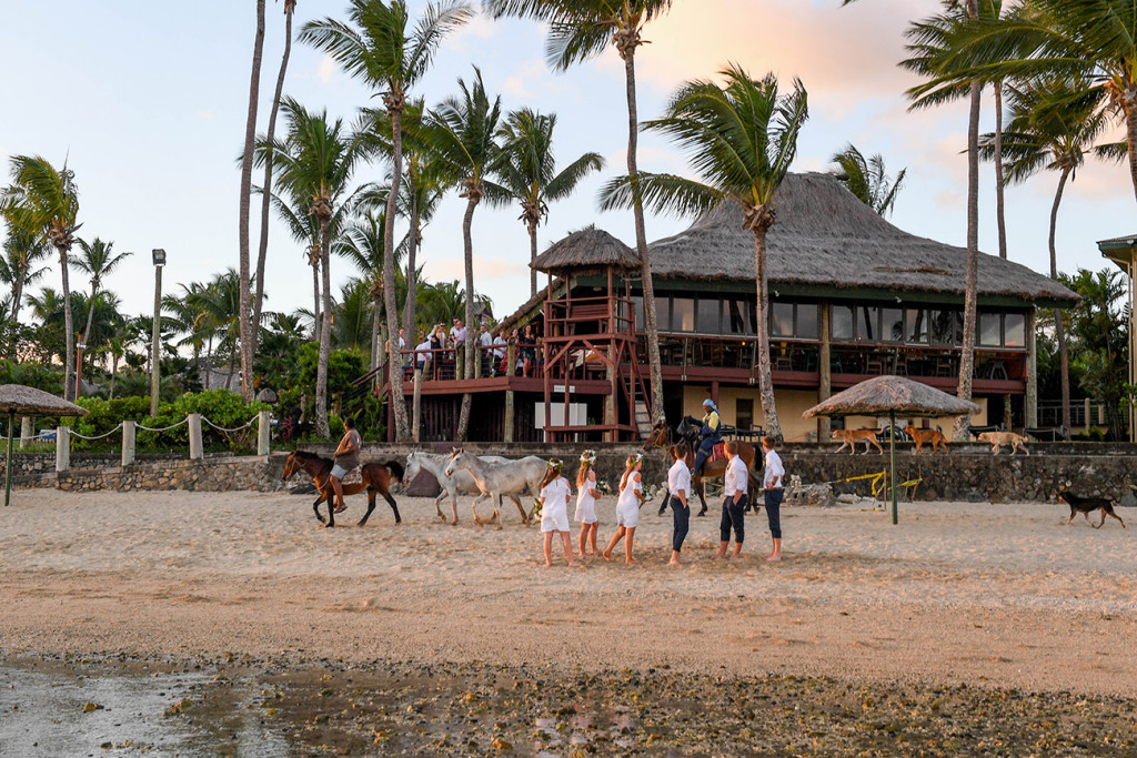 Wideshot of Bridal party against Outrigger hotel Fiji at sunset