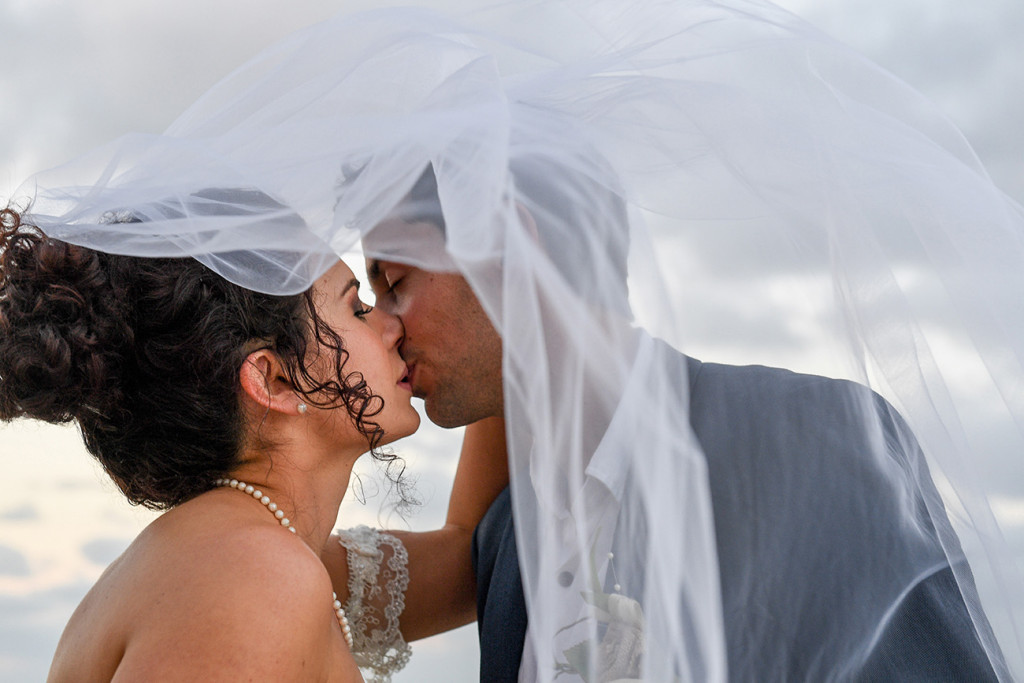 Bride and groom kiss under the veil in boho wedding at the Outrigger Fiji