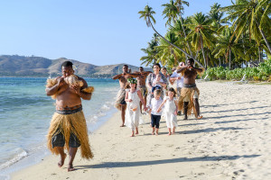 Bride being walked down the aisle by Fiji singers and horns