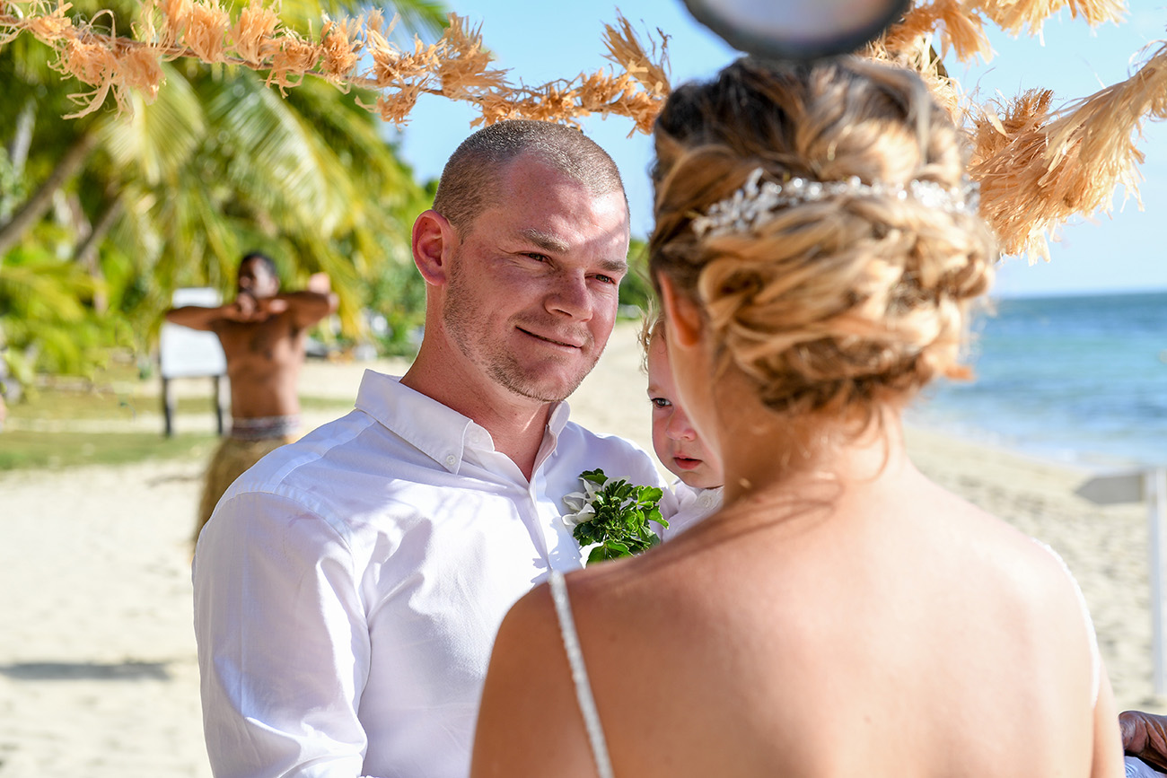 The groom watches with love as his stunning bride says her vows
