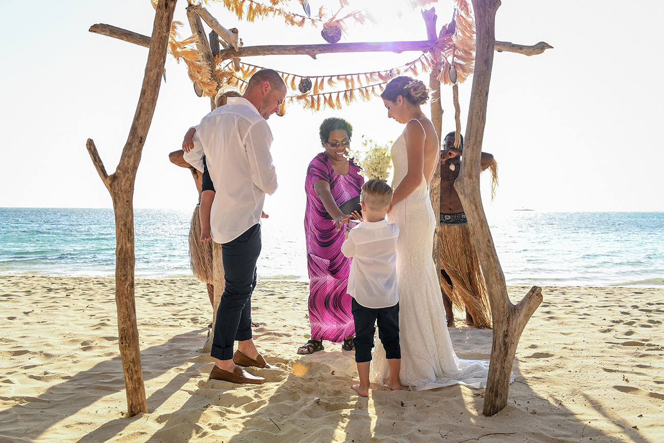Bride, groom and their sons under the traditional Fiji altar against the Fiji ocean