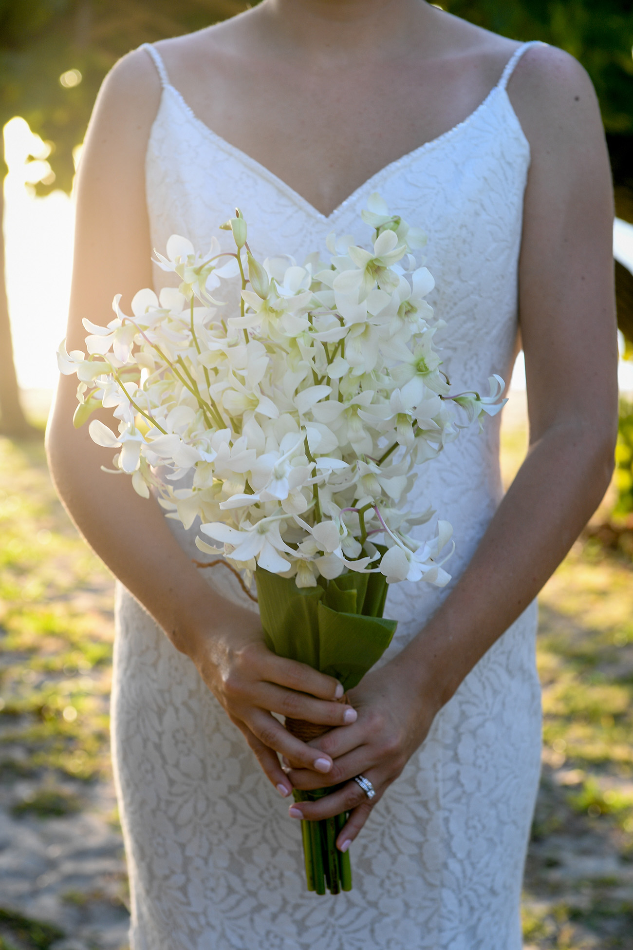 The bride poses with her tropical white flower bouquet