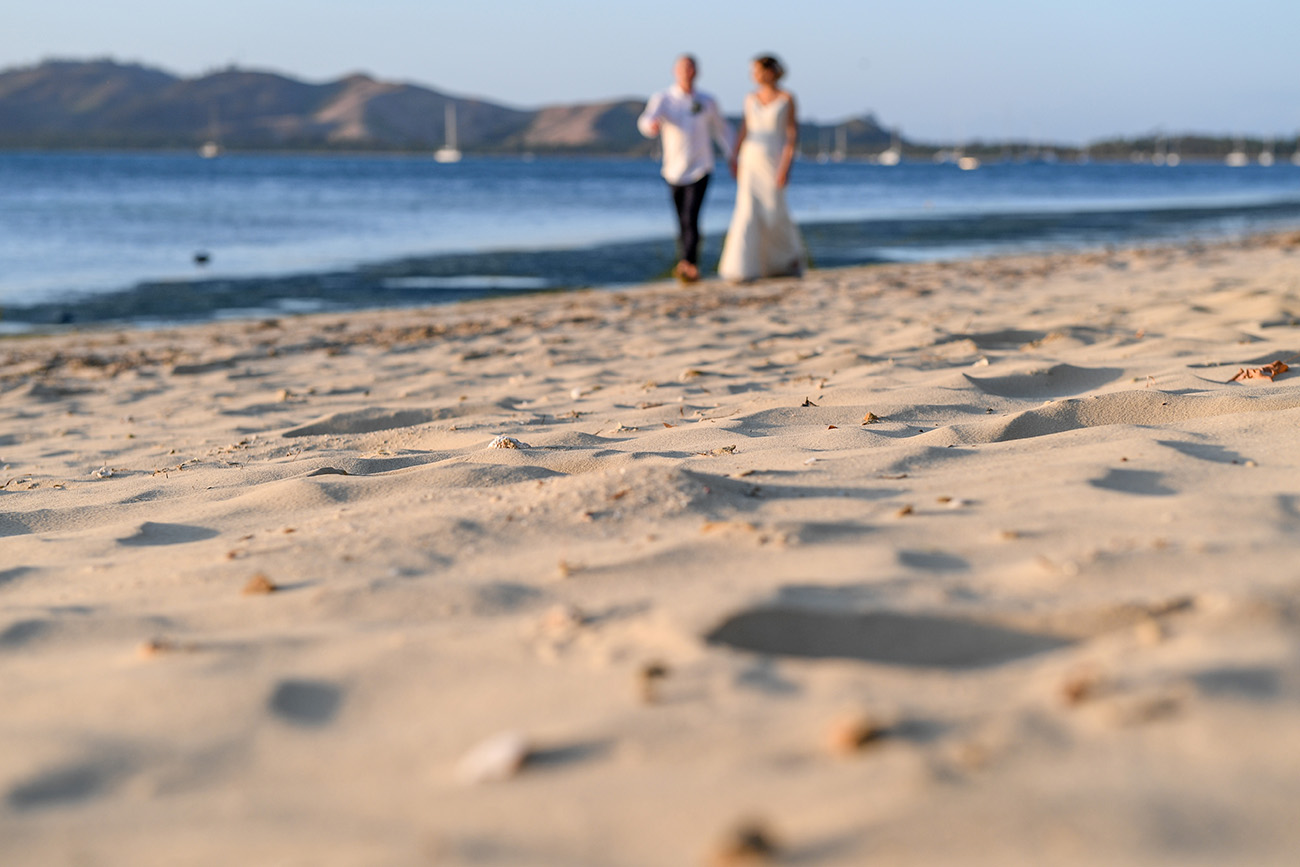 Blurred picture of bride and groom strolling by ocean
