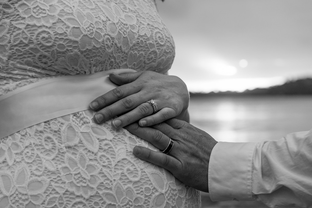 The bride is touching the belly of his pregnant wife balck and white photograph in Fiji