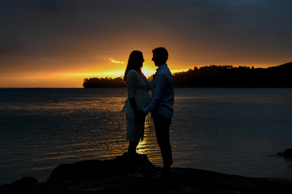 Silhouette of the bride and groom by a sunset on fire in Fiji by the beach