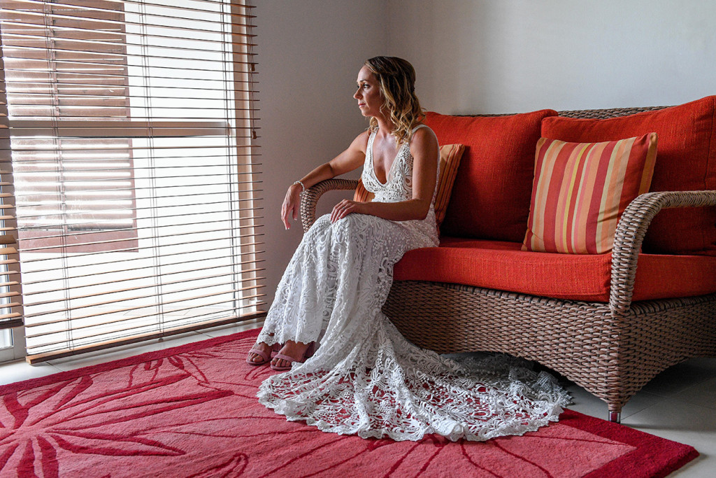 Bride contemplates while seated by long window blinds at the Sheraton Denarau Fiji