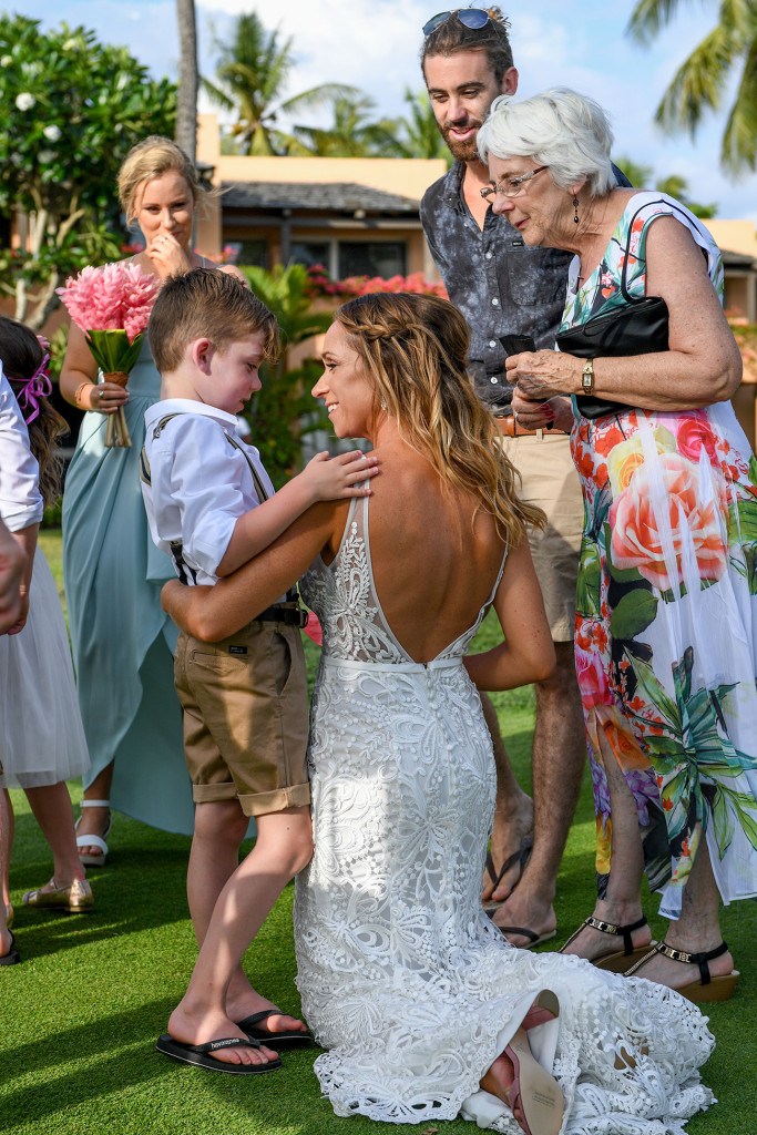 Overjoyed bride kneels beside her son at the wedding