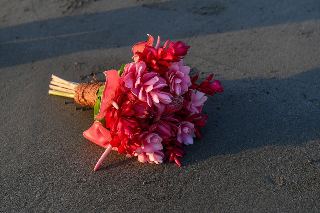 Tropical pink flower bouquet resting on the black sand beach at Denarau Fiji
