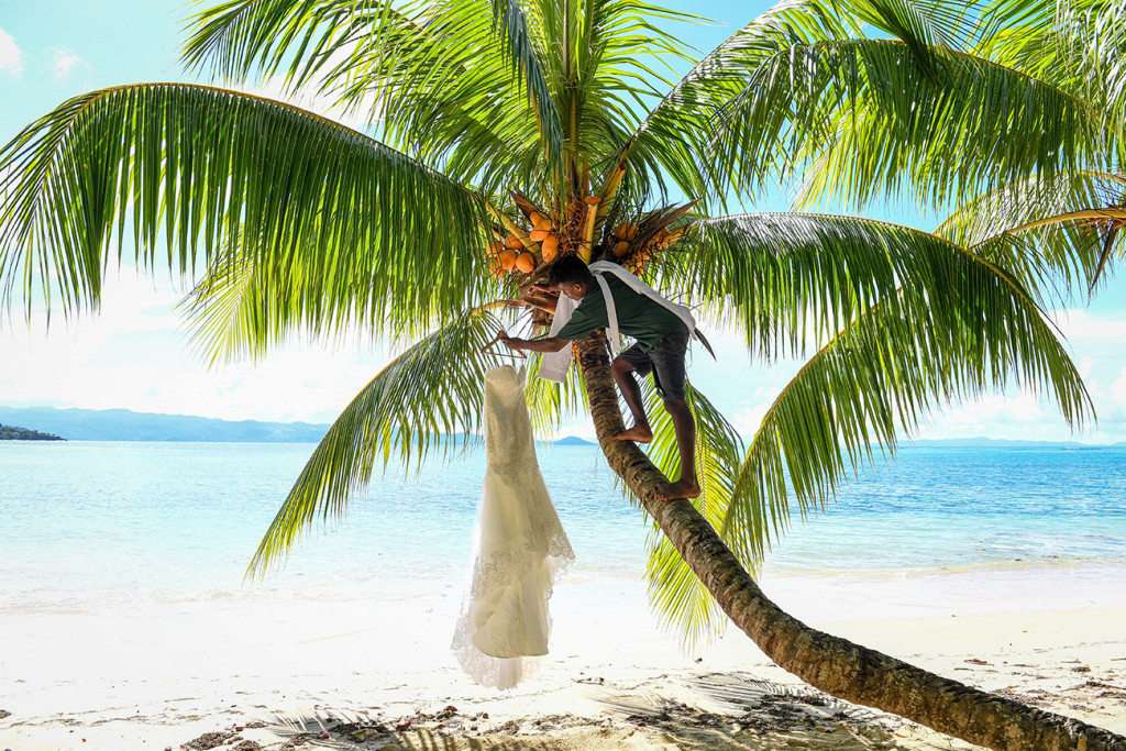 Wedding dress hanging on the palm tree by the beach at Matangi island resort Fiji