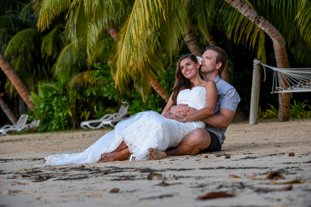 Bride and groom telling eachothers a secret, Matangi island resort in Fiji