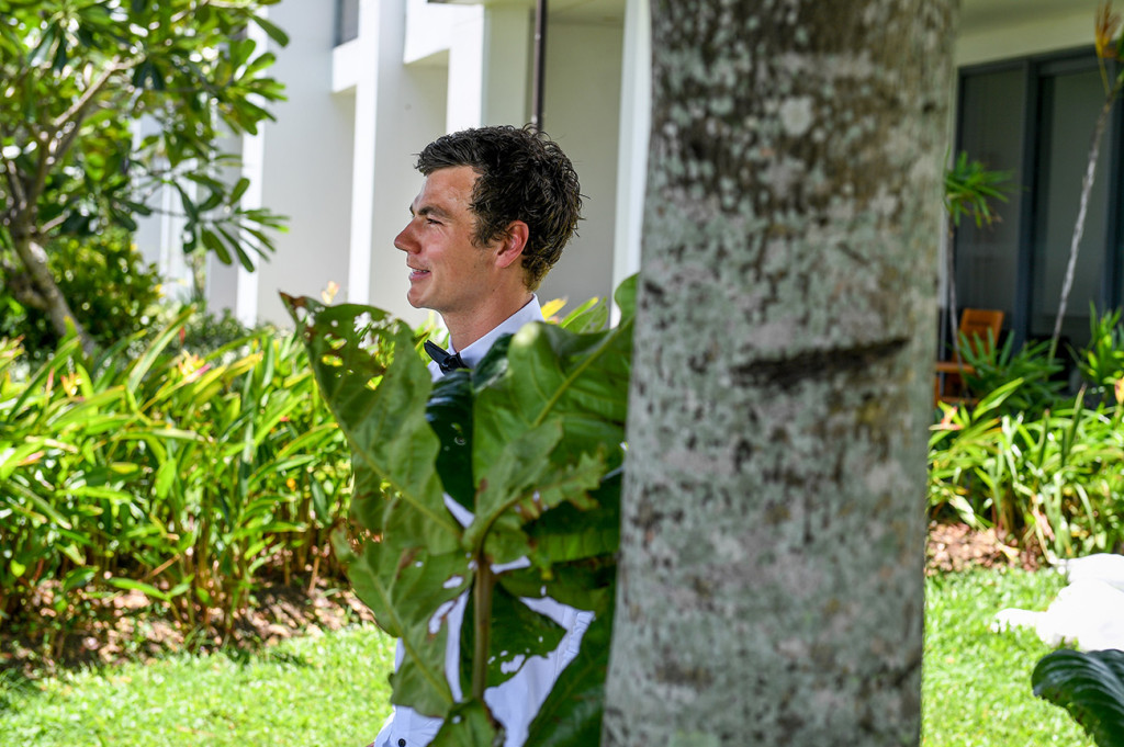 The groom looks onto the Hilton Denarau lawn at his elopement wedding