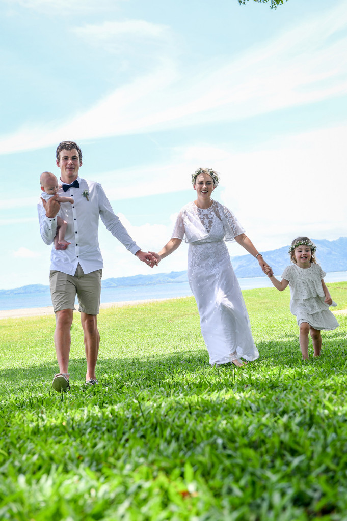 Newly married couple walk with their children on the manicured lawns of the Hilton Denarau Fiji