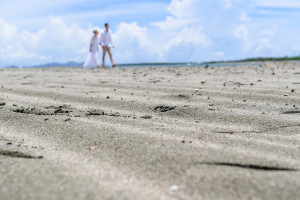Soft focus of the newly married couple strolling on the black sand beach