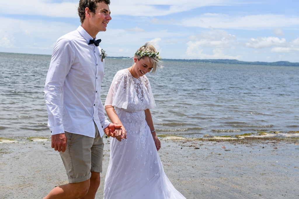 The bride and groom stroll hand in hand on the beach of Denarau Fiji