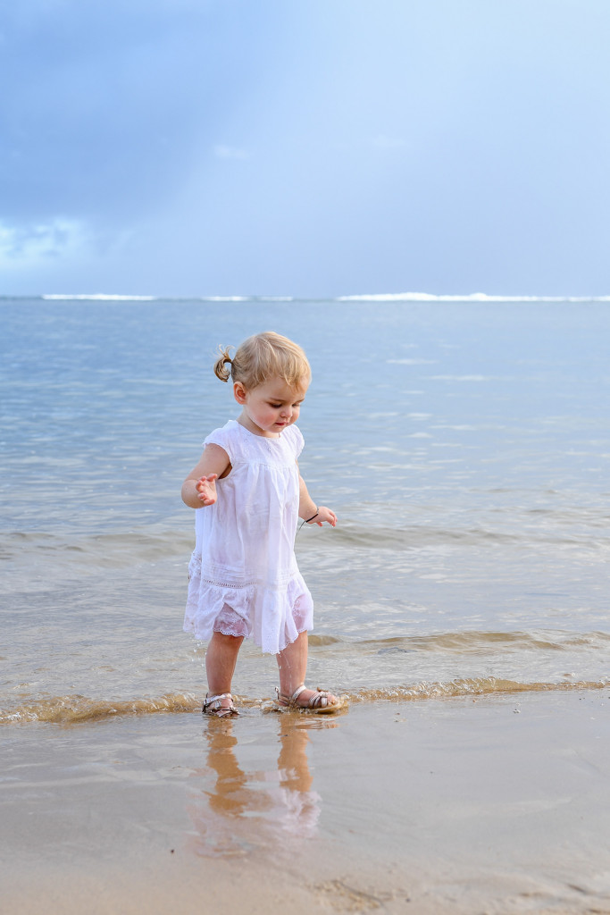 Cute baby girl stumbling in the ocean