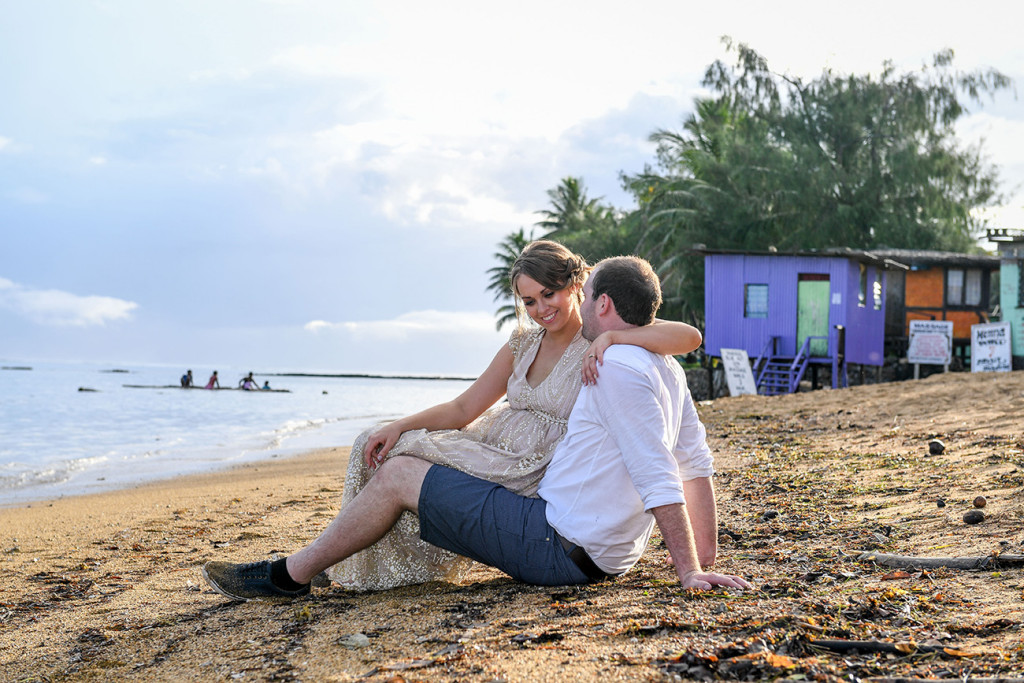 Bride sits in the grooms lap on the beach at Naviti Fiji