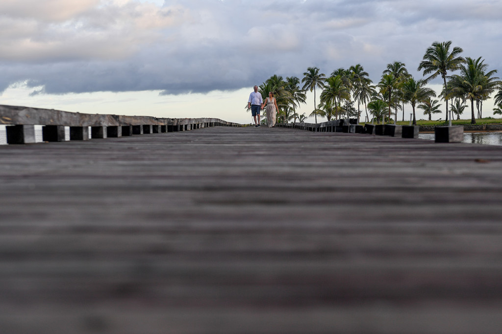Bride and groom stroll on bridge against palm trees at Naviti Resort Fiji