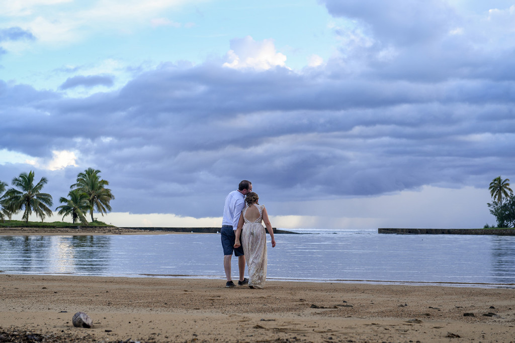 A stroll against magnificently stormy sunset by the bride and groom