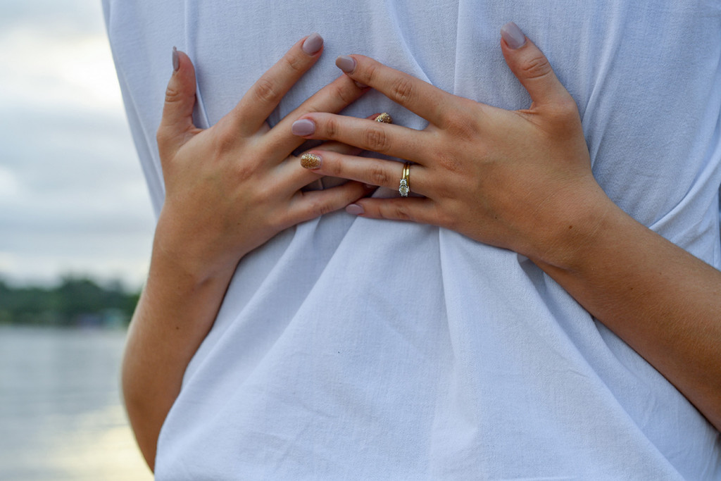 Closeup of bride's hands behind her groom's back