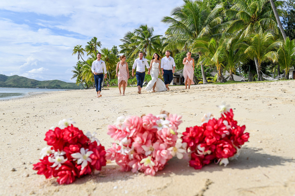 Ginger flower bouquet in sharp focus as the bridal party walk on the beach in the background?