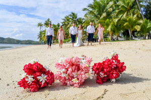Ginger flower bouquet in soft focus as the bridal party walk on the beach in the background?