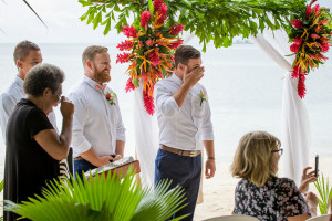The groom wipes a tear as he watches his bride walk down the aisle