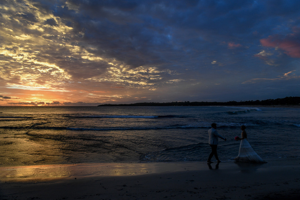 Bride and groom dance on the beach against the Blue and orange sunset at the Yatule Resort Fiji