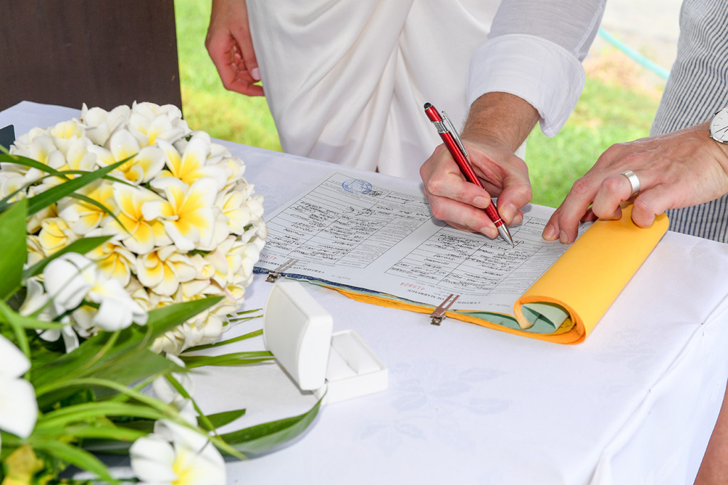 Bride and groom sign their wedding cerfificates