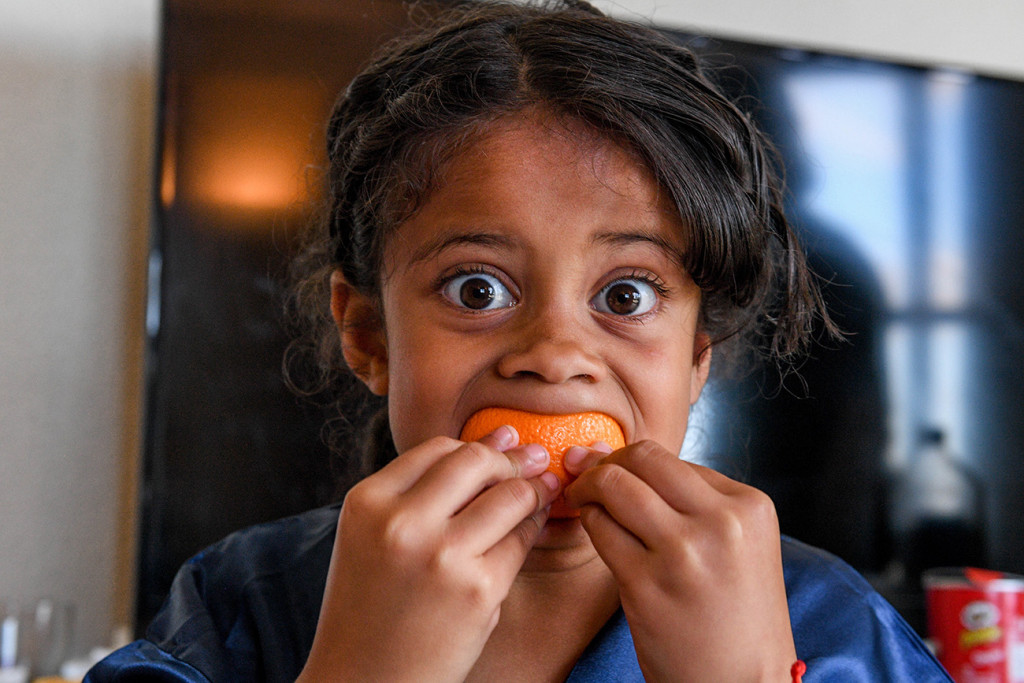 Cute Samoan girl eats an orange