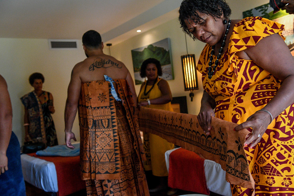 A Samoan mother helps her son tie the Traditional Masi
