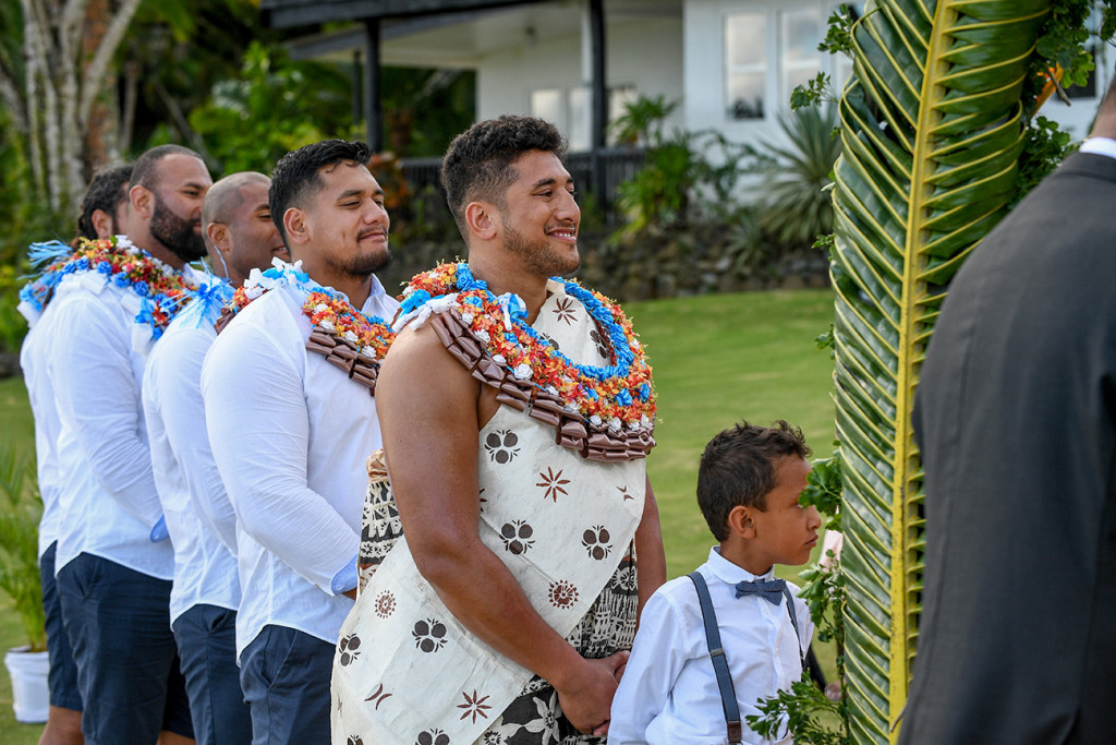 Groomsmen and bestman smile as they watch the couple exchange vows