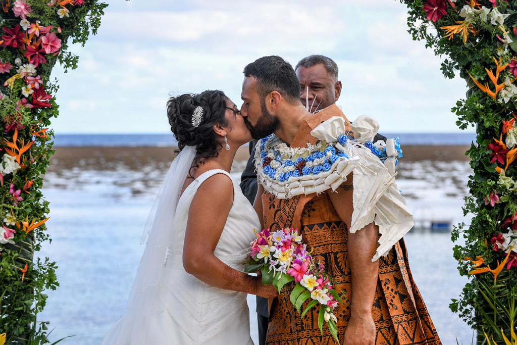 Bride and groom kiss overlooking the sea at Warwick Fiji