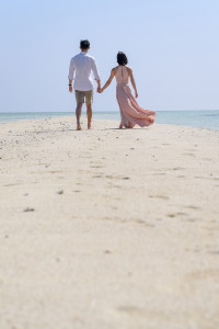 The newly married couple stroll in the reef path on the beach