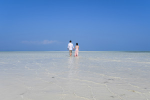 The couple wades in the subsiding waters of Malolo Lai Lai Island at Lomani Island Resort