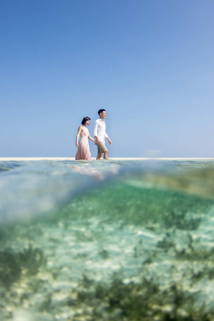 A partial underwater shot of the couple wading into deep waters of the ocean