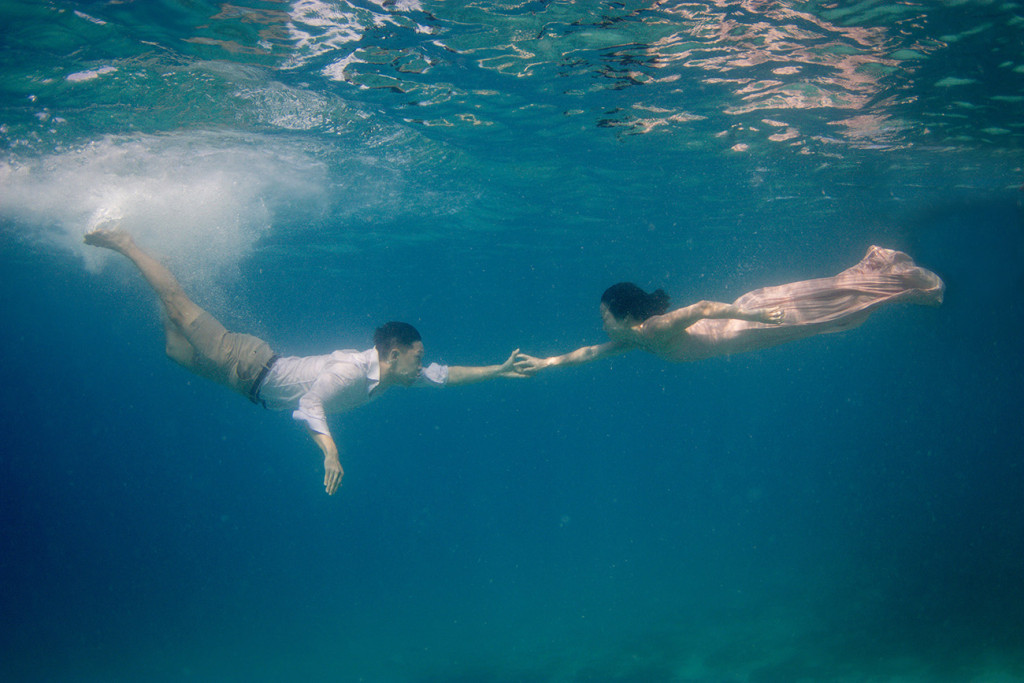 The couple recreates the touch of Adam underwater