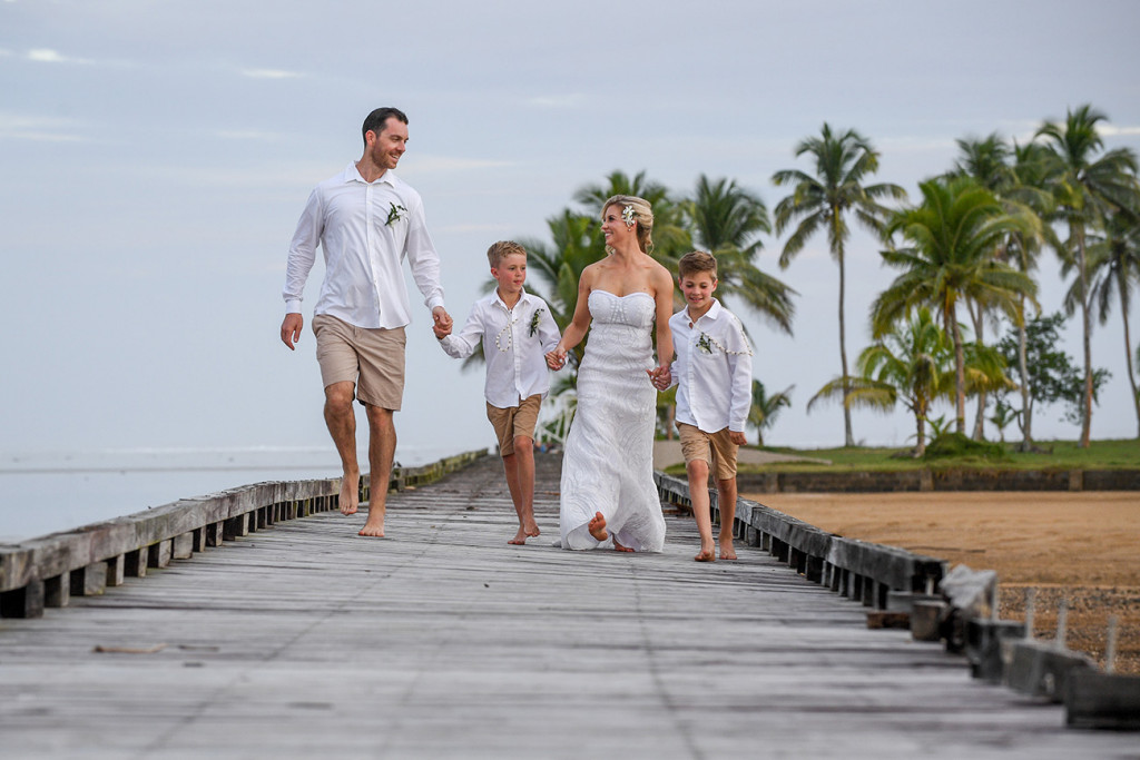 The happily married family walks hand in hand down the dock in Fiji