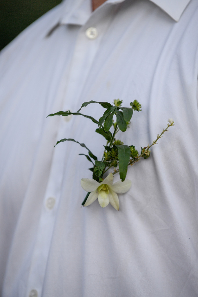 Closeup on groom's frangipani flower boutonniere
