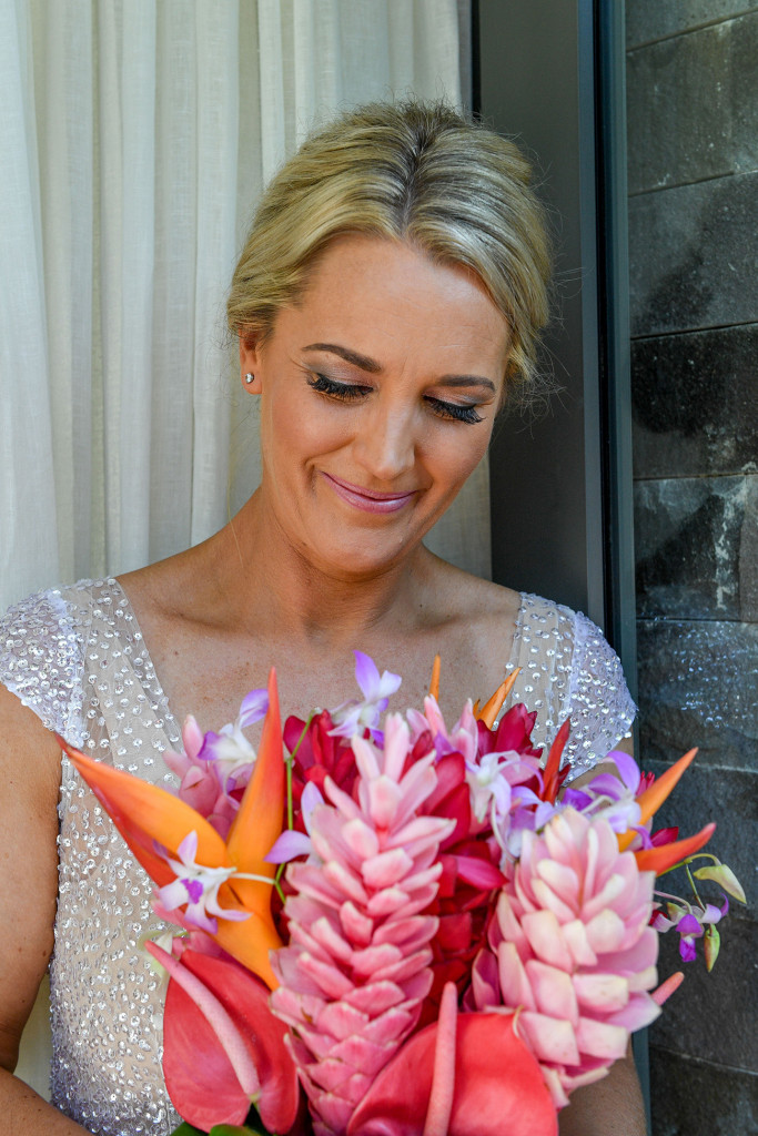 The stunning bride smiles as she carries her assorted, colourful Fiji flower bouquet