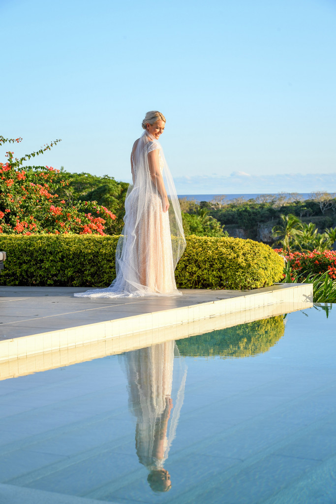 The breathtaking bride stares at her reflection in the swimming pool