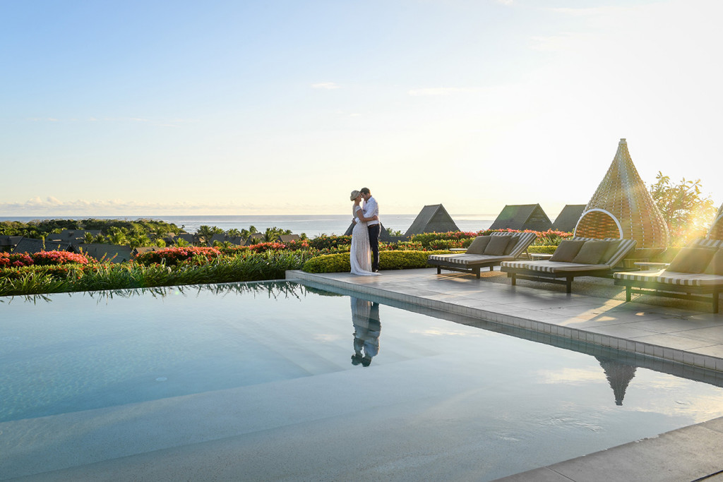 Breathtaking kiss at the edge of the pool against the glorious Pacific