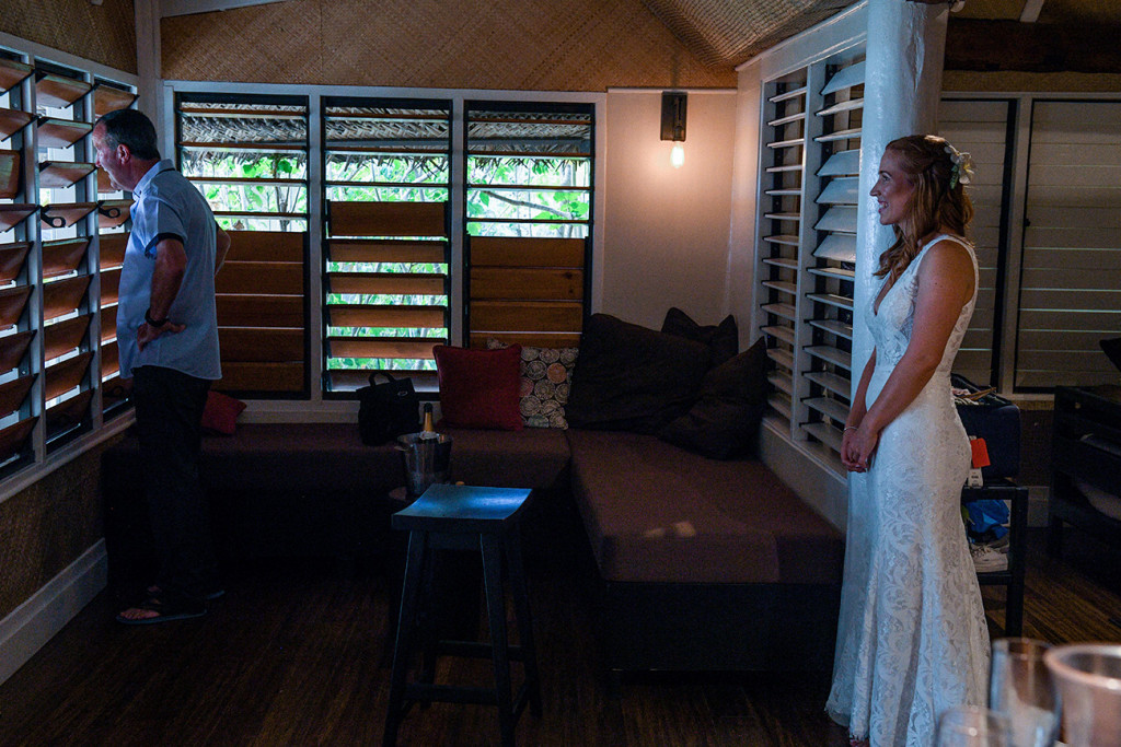 The bride and her father peeping through the blinds to check out the wedding venue