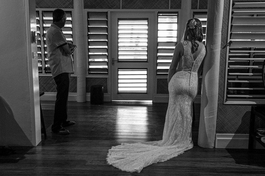 Monochrome photograph of bride waiting by the door