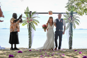 The newly married couple walk from the altar facing the sea