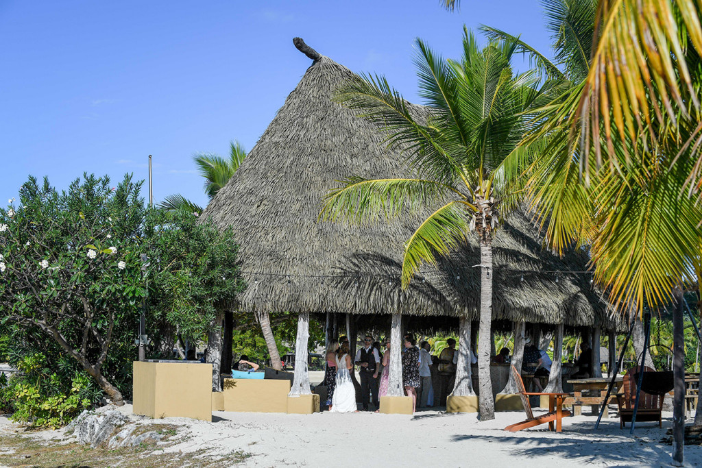 Guests mingle in thepalm thatched roof of the island bar at Musket