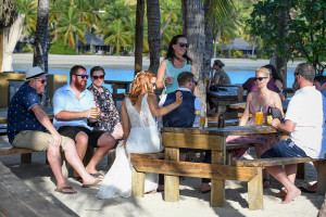 The bride and her guests enjoy drinks and cocktails under palm trees at Musket Cove Fiji