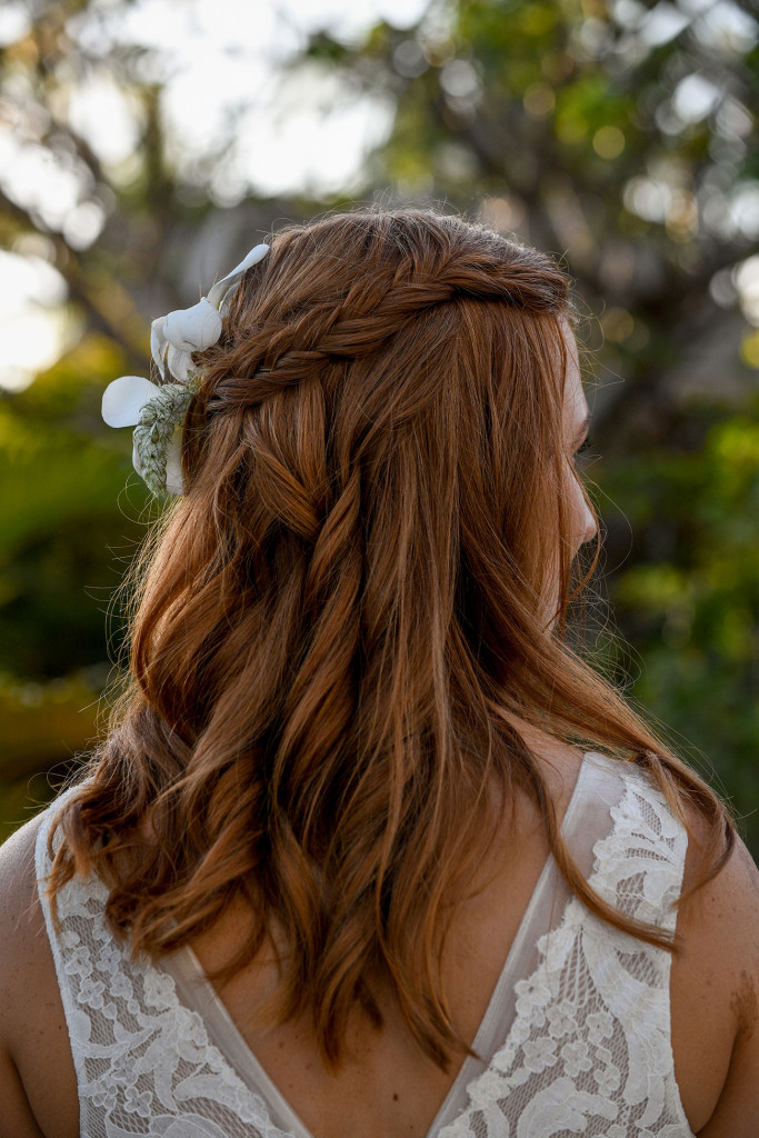 Simple lace braid with white frangipani on bride's hair