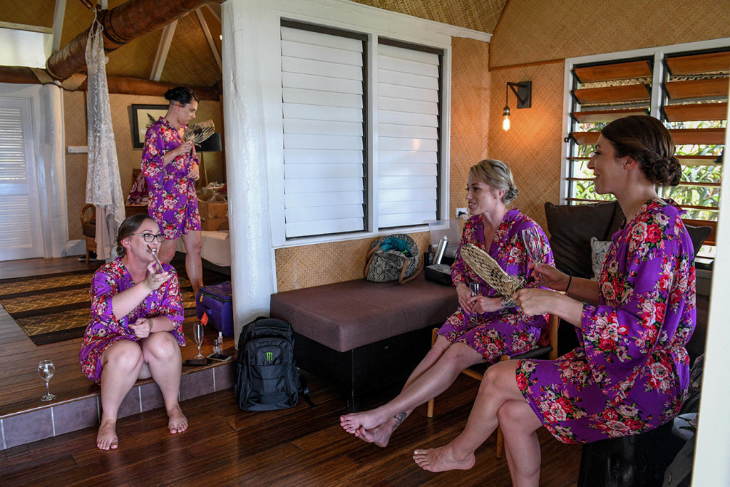 Bridesmaids in floral purple kimonos while preparing for the wedding